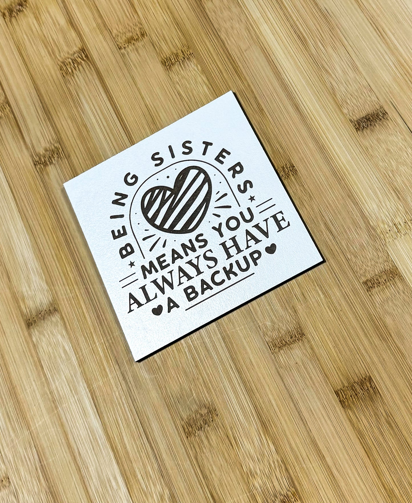 a sticker on a wooden surface that says, being sisters means you always have