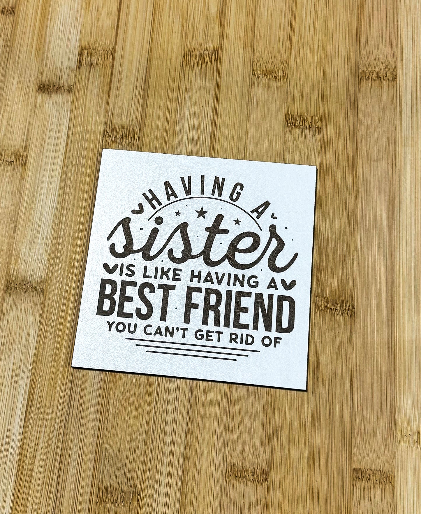 a sticker on a wooden surface that says having a sister is like having a