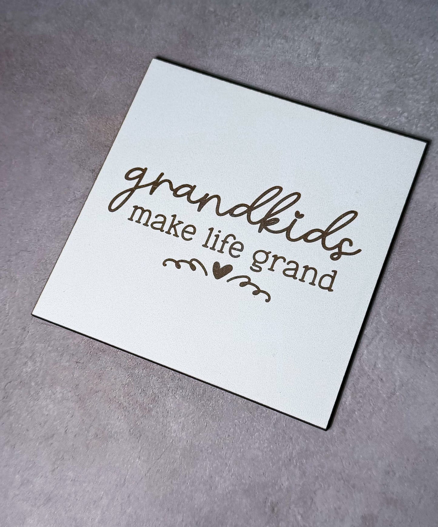 a piece of paper that says grandkids make life grand