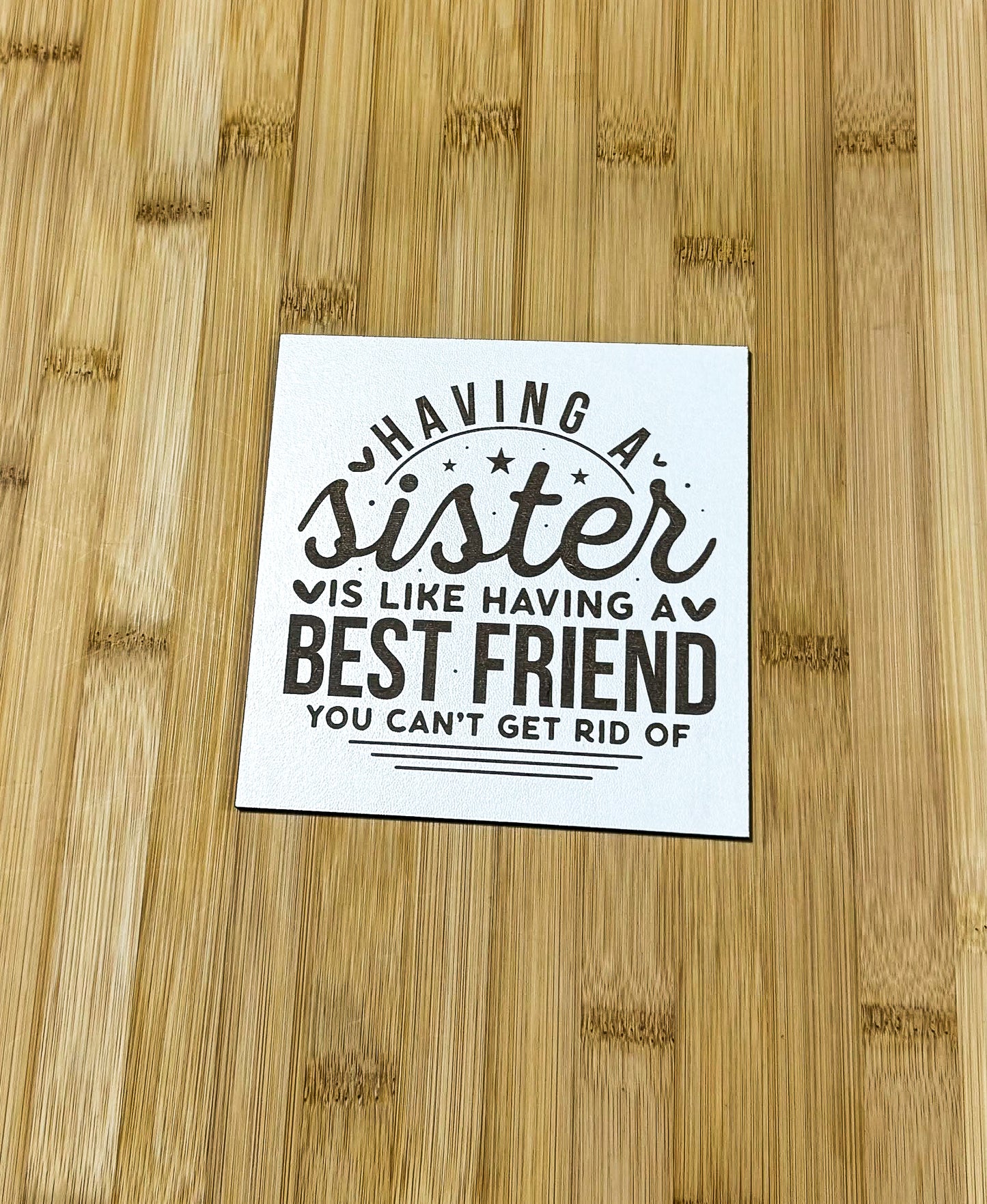 a sticker on a bamboo table that says having a sister is like having a