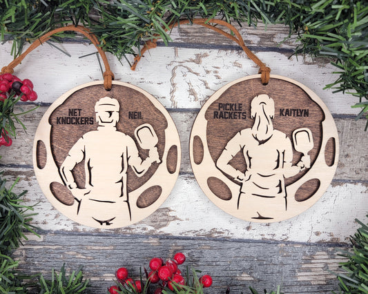 two wooden plaques with a man and a woman holding tennis rackets