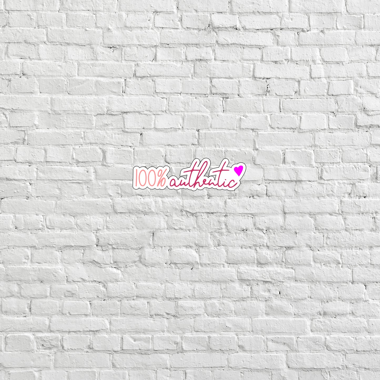 a white brick wall with a pink sticker on it